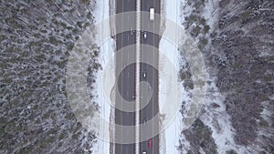 Winter traffic on snow highway aerial view. Cars driving on blizzard road