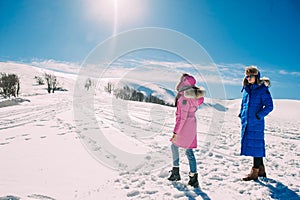 Winter, two girls having fun in the snow in the mountains