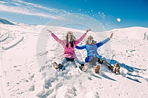 Winter, two girls having fun in the snow in the mountains