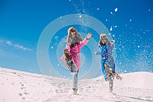 Winter, two girls having fun in the snow in the mountains