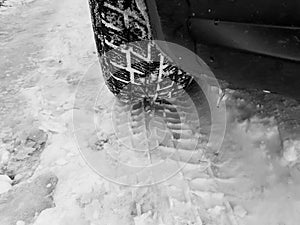 Winter tyre with tracks close up shot on the snow in black and white