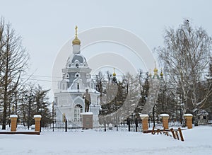 Winter urban landscape with snow from buildings and Orthodox Church