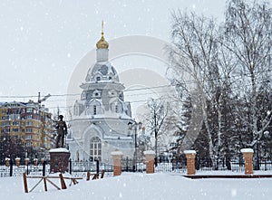 Winter urban landscape with snow from buildings and Orthodox Church