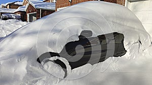 Winter urban scene in Canada. Vehicles covered with snow in the winter blizzard in the parking. Cars in snowdrifts after a snowfal