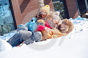 Winter vacation. Family time together outdoors lying on snow laughing playful