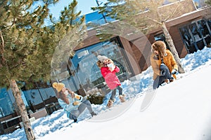 Winter vacation. Family time together outdoors playing snowballs cheerful