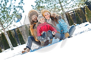 Winter vacation. Family time together outdoors sitting throwing snow laughing cheerful