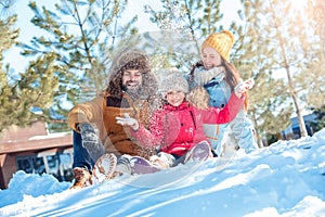 Winter vacation. Family time together outdoors sitting throwing snow laughing joyful