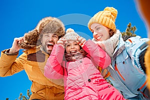 Winter vacation. Family time together outdoors taking selfie shhowing thumbs up smiling toothy bottom view