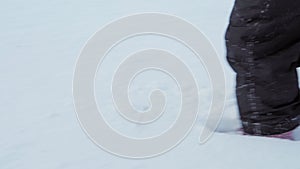 Winter, vacation, games, family concept - close up child runs through deep snow. Children feet tread on snowy path