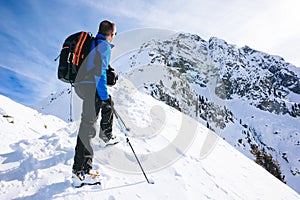 Winter vacation: mountaineer takes a rest looking at the mountain panorama