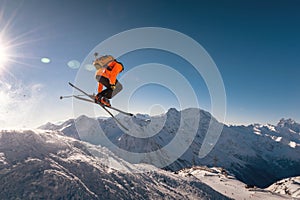 winter vacation at the ski resort. skier quickly fly in the air doing a stunt heli-skiing on the background of snow