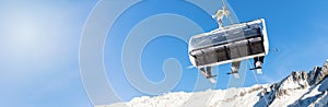 winter vacation - skiers in a chairlift against blue sky