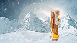 Winter vacations. Big glass of light cold foamy beer over snow-capped mountains background. Holidays, vacation, drinks