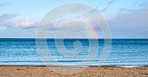 Winter view of Baltic sea with beach and rainbow over maritime horizon offshore Gdynia Orlowo district of Tricity in Poland