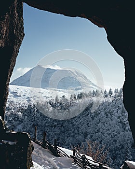 Winter view of Clerziou caves in Auvergne with snow-capped Puy de Dome.