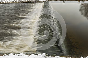 Winter view for Malse river and weir in snowy cold cloudy day