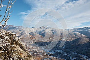 winter, view from mountain to small town, snow rocks and stones, village in distance