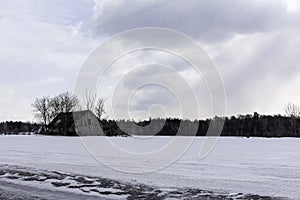 Winter view of the wooden house and the trees in Petrie Island Area near Ottawa River