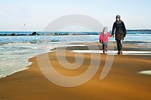 Winter walk by Baltic sea, mother and daughter