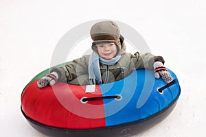 Winter walk, boy rides a Snow-tubing