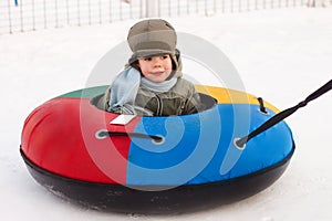 Winter walk, boy rides a Snow-tubing