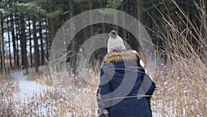 Winter walk in the woods through tall prairie grass