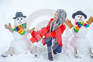 Winter waman with Snowman on snow background. Winter portrait of beauty girl in snow Garden. Cute snowmen with winter