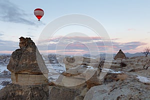 Winter warm dawn with red balloon on hotfire balloons festival, cappadocia, turkey, kappadokya