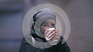 Winter Warmth: Woman Cozying Up in Underground Passage with Hot Coffee