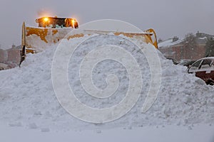 Wheel loader machine tractor removing snow. Clearing the road from ice and snow