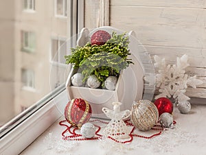 Winter window with Christmas toys and Selaginella martensii