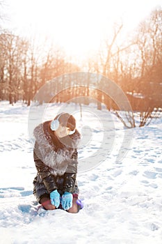 Winter woman on background of winter landscape, sun. Fashion girl in forest wonderland. Winter sunset scene. Model in sunlight, b