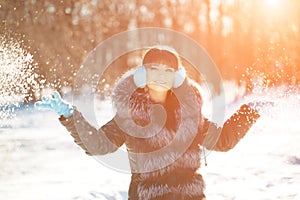 Winter woman on background of winter landscape? sun. Fashion girl in forest wonderland. Winter sunset scene. Model in sunlight, b