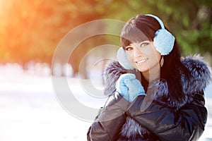 Winter woman on background of winter landscape? sun. Fashion girl in forest wonderland. Winter sunset scene. Model in sunlight, b