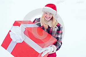 Winter woman with gift. Christmas Girl holding a big gift. Crazy Christmas girl pushes a big gift on snow winter