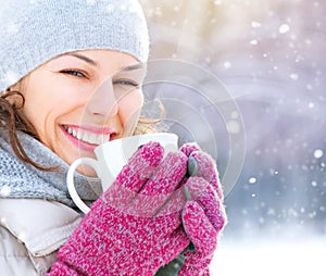 Winter woman with hot drink outdoors photo