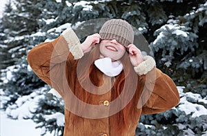 Winter woman outdoor portrait with cap covering eyes