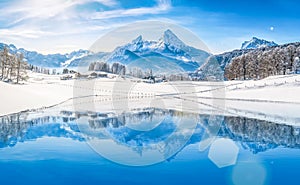 Winter wonderland in the Alps reflecting in crystal clear mountain lake