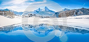 Winter wonderland in the Alps reflecting in crystal clear mountain lake