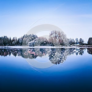 Winter wonderland and Christmas landscape. Frozen lake in snowy mountains and trees covered with snow as holiday