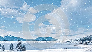 Winter wonderland and snowing Christmas landscape. Frozen lake in snowy mountains and trees covered with snow as holiday