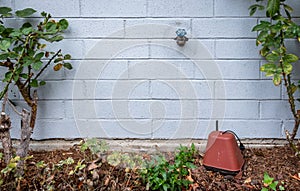 Winterization, outside faucet on a blue gray painted brick wall photo