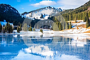 Winterly snowy Spitzingsee in Alps in Bavaria, with beautiful reflection