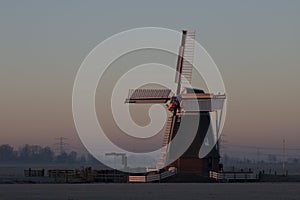 Dutch windmill in a winterscenery at night photo