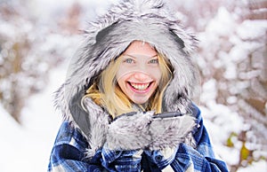 Wintertime. Closeup portrait of smiling winter girl in snowy park. Winter holidays and vacation. Beautiful woman in warm