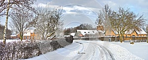 Wintertime in the village. A road running through a snowcapped town in the Danish countryside.