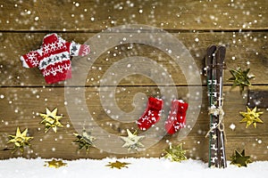 Wintry christmas decoration with ski and winter clothes on wooden background. photo