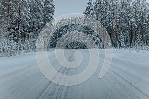 Wintry Path Through a Chilly Forest with Snow Covered Trees. Winter road through snowy forest