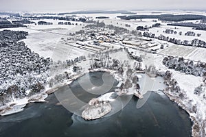 wintry scenery with a lake in the foreground and a small village in the background